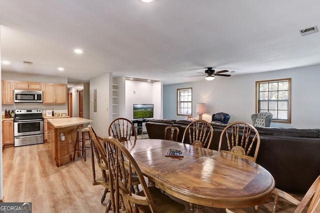 dining room with ceiling fan and light wood-type flooring