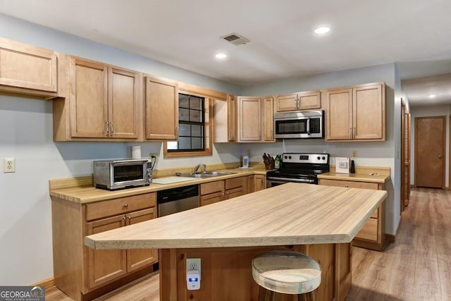 kitchen featuring sink, light hardwood / wood-style flooring, a center island, and stainless steel appliances