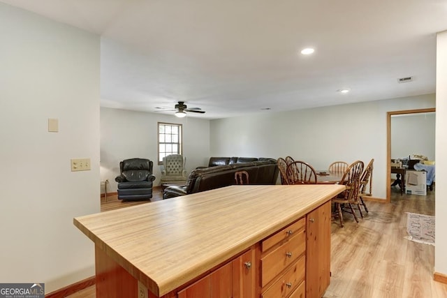 kitchen with a kitchen island, ceiling fan, and light wood-type flooring