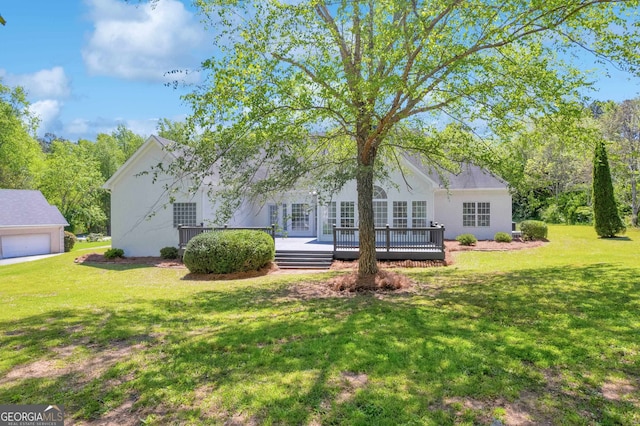 view of front facade with a garage, a deck, and a front yard