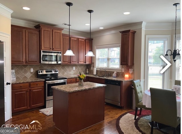 kitchen featuring dark stone countertops, plenty of natural light, stainless steel appliances, and a center island