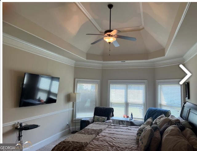 carpeted bedroom featuring crown molding, ceiling fan, and a raised ceiling