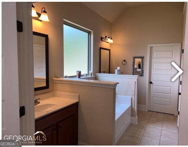 bathroom featuring vanity with extensive cabinet space, tile floors, vaulted ceiling, and a bath