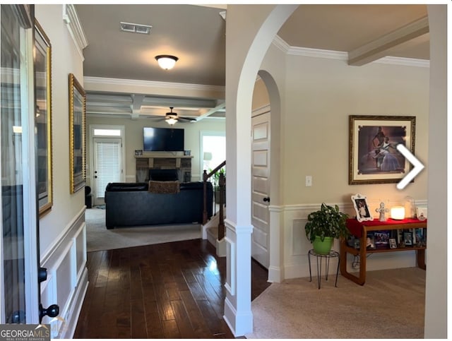 hallway with beamed ceiling, dark hardwood / wood-style floors, and ornamental molding