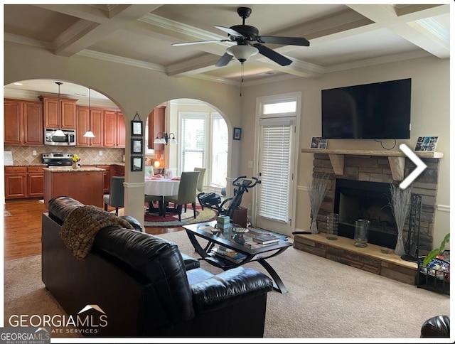 carpeted living room with a fireplace, beam ceiling, and coffered ceiling