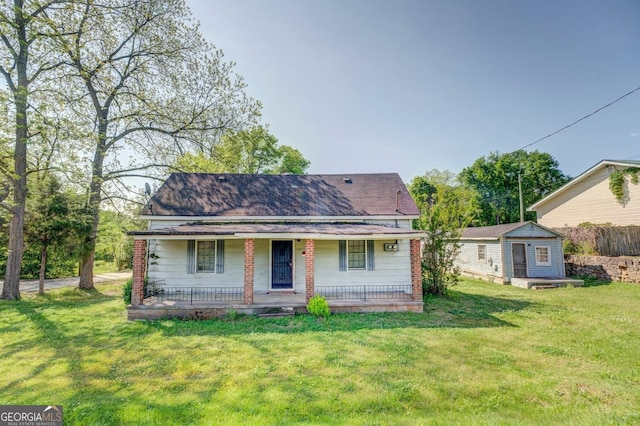 rear view of property featuring a storage unit and a lawn