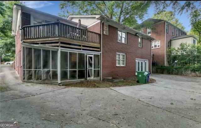 rear view of property with a balcony and a sunroom