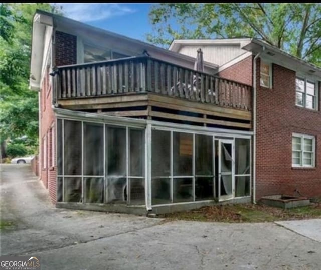 back of house with a balcony and a sunroom