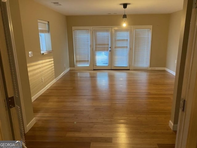 empty room featuring french doors and hardwood / wood-style floors