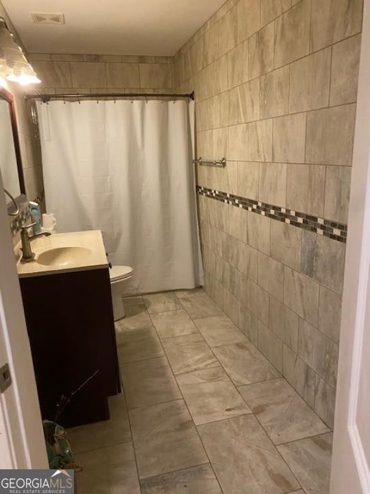 bathroom featuring tile flooring, oversized vanity, and toilet