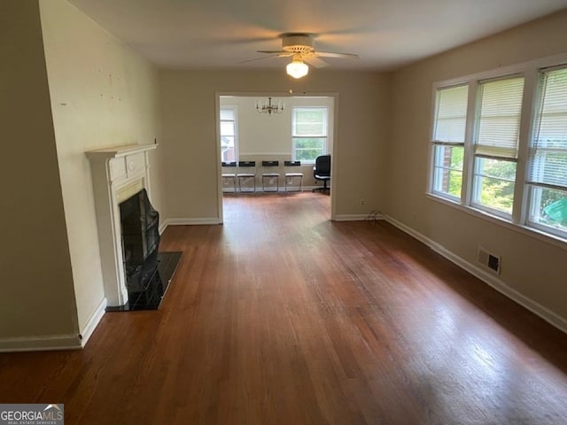 unfurnished living room with wood-type flooring, plenty of natural light, and ceiling fan