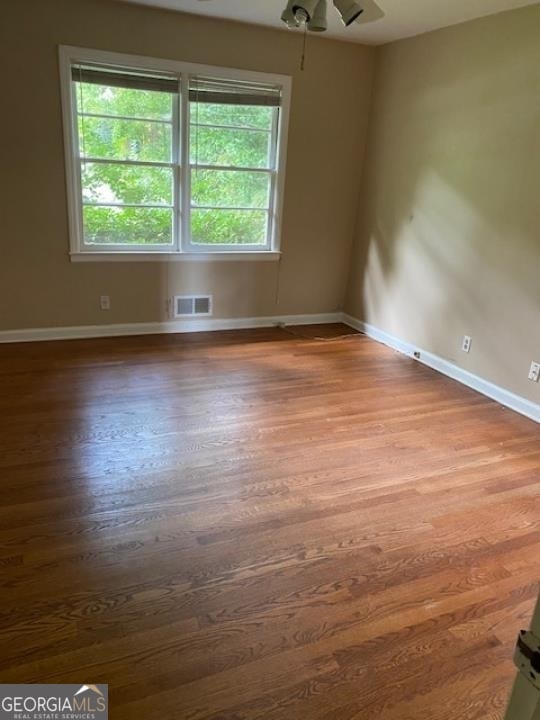 spare room featuring wood-type flooring and ceiling fan