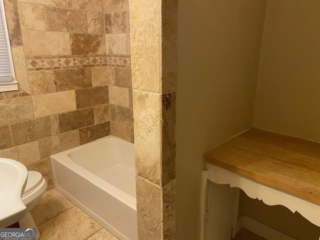 bathroom with tile flooring, tile walls, and toilet