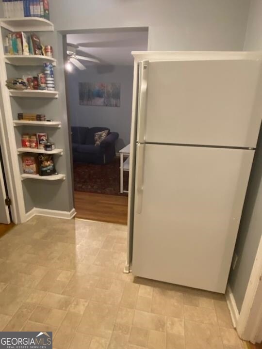 kitchen featuring light tile flooring, ceiling fan, and white refrigerator