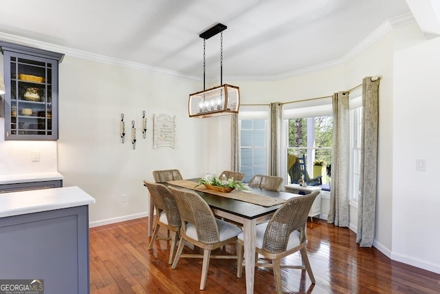 dining space featuring a notable chandelier, crown molding, and dark wood-type flooring