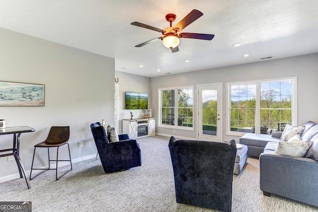 carpeted living room with ceiling fan