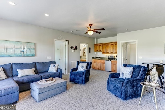 living room with light carpet, sink, and ceiling fan