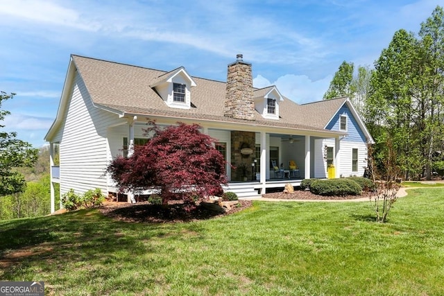 view of front of home with ceiling fan and a front yard