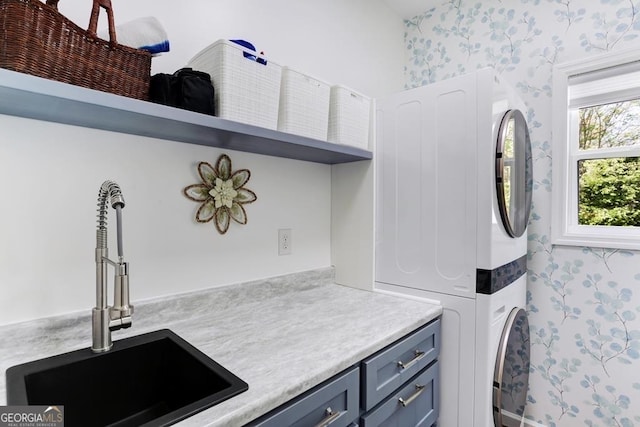 laundry area featuring cabinets, sink, and stacked washer and dryer