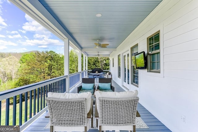 deck with an outdoor living space and ceiling fan