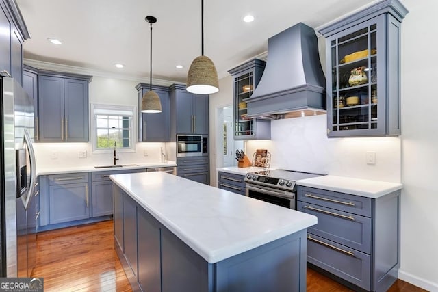 kitchen with custom exhaust hood, a kitchen island, backsplash, hardwood / wood-style floors, and stainless steel appliances