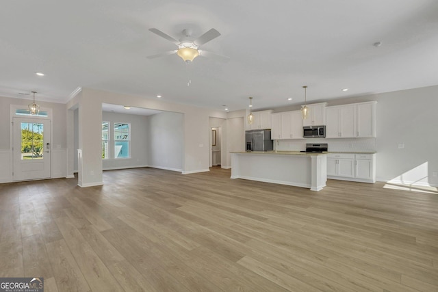 unfurnished living room featuring ceiling fan and light wood-type flooring