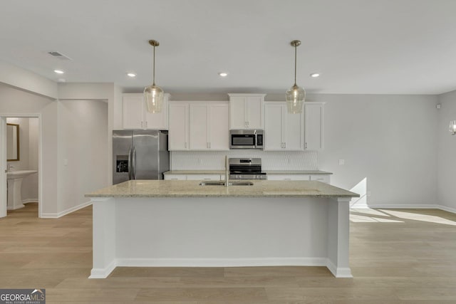 kitchen featuring light stone countertops, appliances with stainless steel finishes, and white cabinets