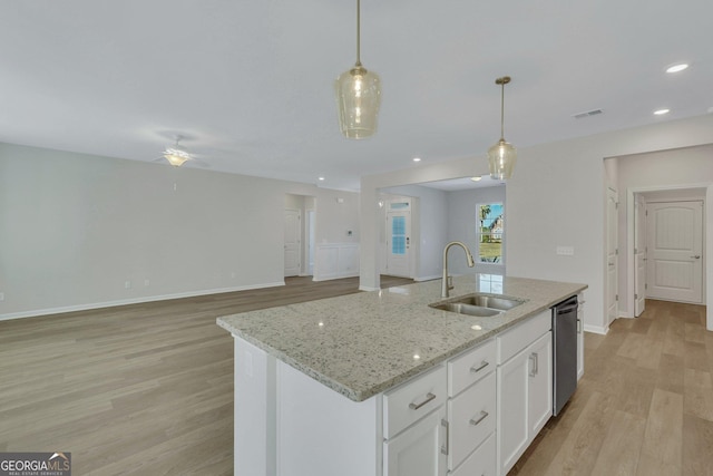 kitchen with sink, dishwasher, pendant lighting, a kitchen island with sink, and white cabinets