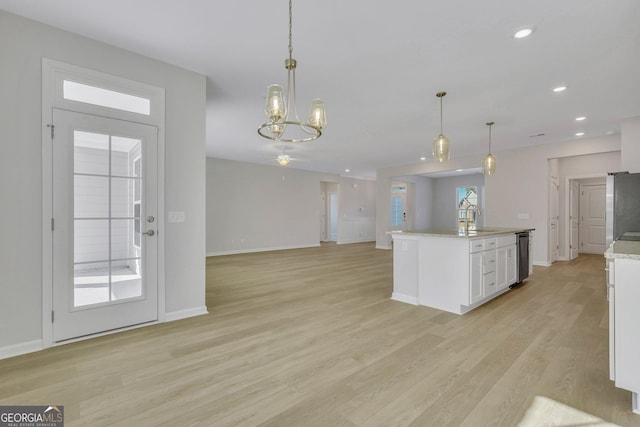 kitchen with white cabinetry, sink, pendant lighting, and light wood-type flooring