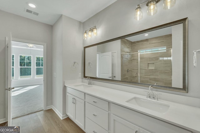 bathroom with hardwood / wood-style flooring, vanity, and a shower with shower door