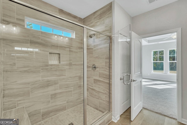 bathroom with an enclosed shower and hardwood / wood-style floors