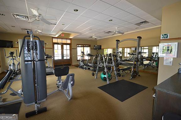 workout area featuring a drop ceiling, french doors, and ceiling fan