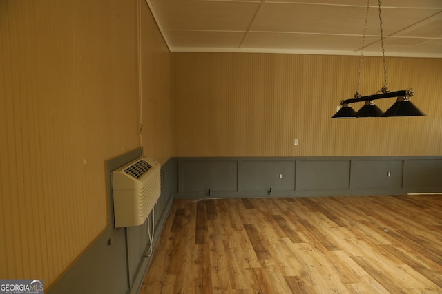 spare room with wood-type flooring and an AC wall unit