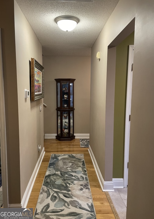 corridor featuring hardwood / wood-style floors and a textured ceiling