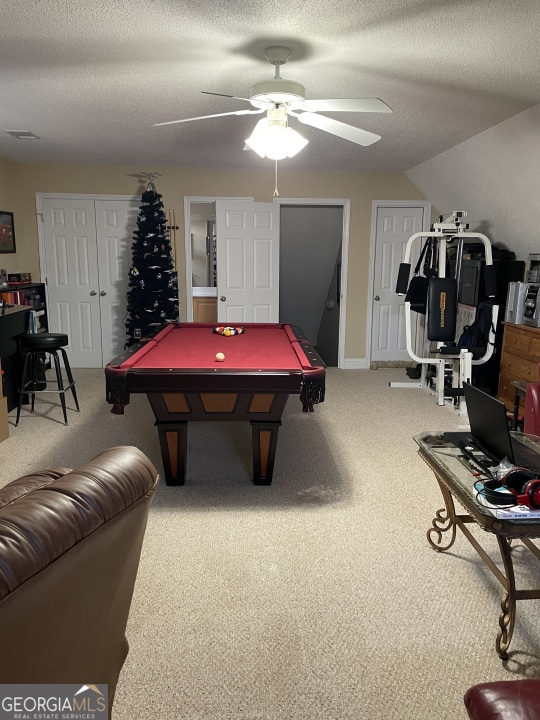 game room with ceiling fan, pool table, carpet flooring, and a textured ceiling