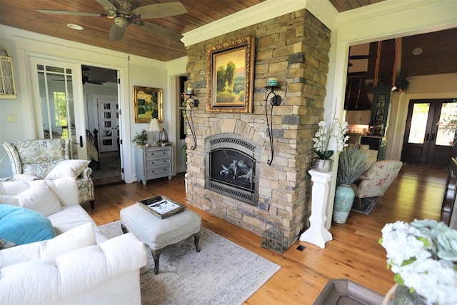 living room featuring wood ceiling, a fireplace, hardwood / wood-style floors, and ceiling fan