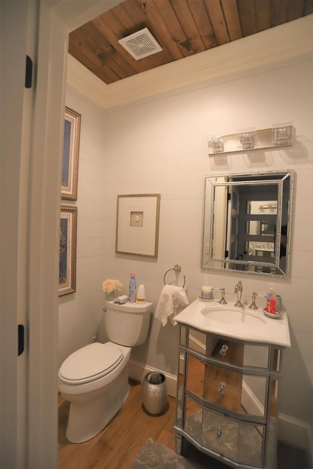 bathroom with vanity, toilet, wooden ceiling, crown molding, and hardwood / wood-style floors