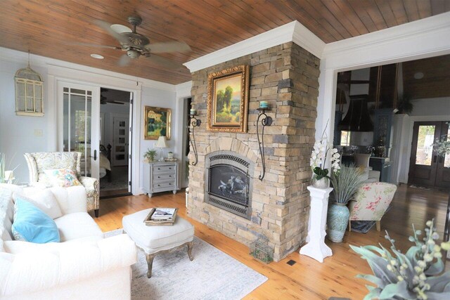 living room featuring wood ceiling, a fireplace, crown molding, ceiling fan, and hardwood / wood-style flooring