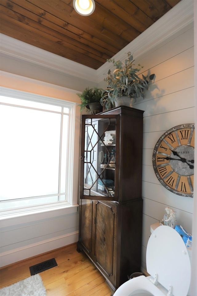 bathroom with wood ceiling, wood walls, toilet, and hardwood / wood-style flooring