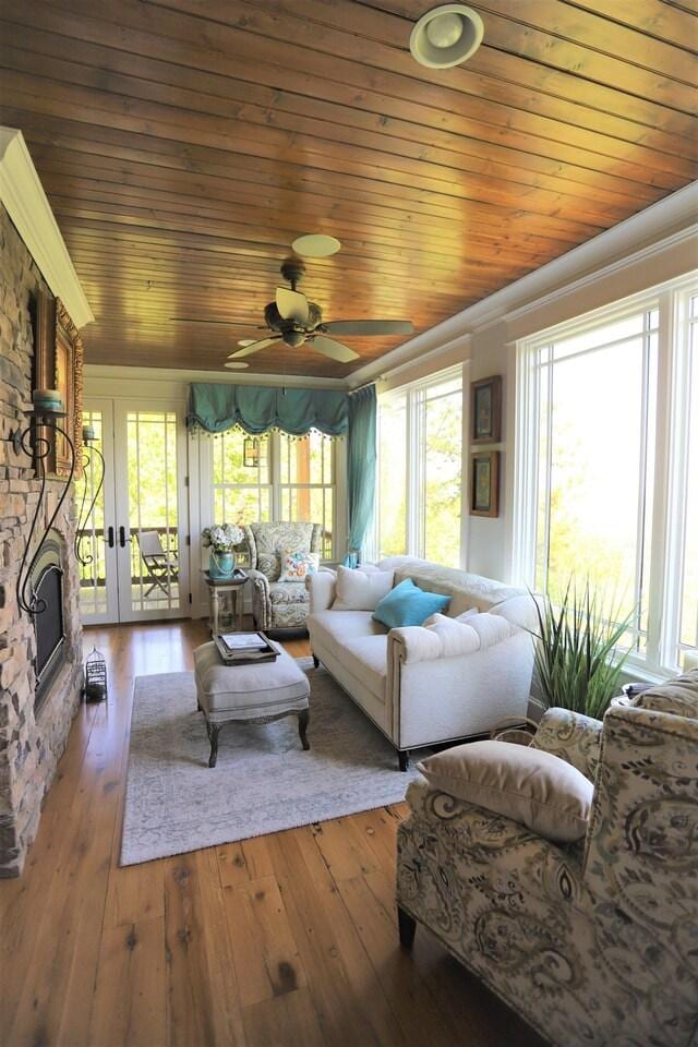 living room featuring wood-type flooring, wood ceiling, and a wealth of natural light