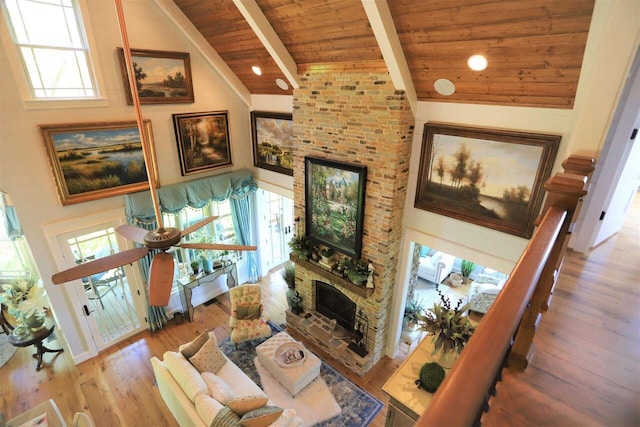 living room with beamed ceiling, a wealth of natural light, high vaulted ceiling, and wooden ceiling