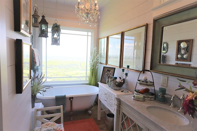 bathroom with an inviting chandelier, a bath, plenty of natural light, and vanity