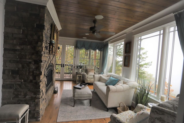 sunroom / solarium featuring wood ceiling, ceiling fan, and french doors