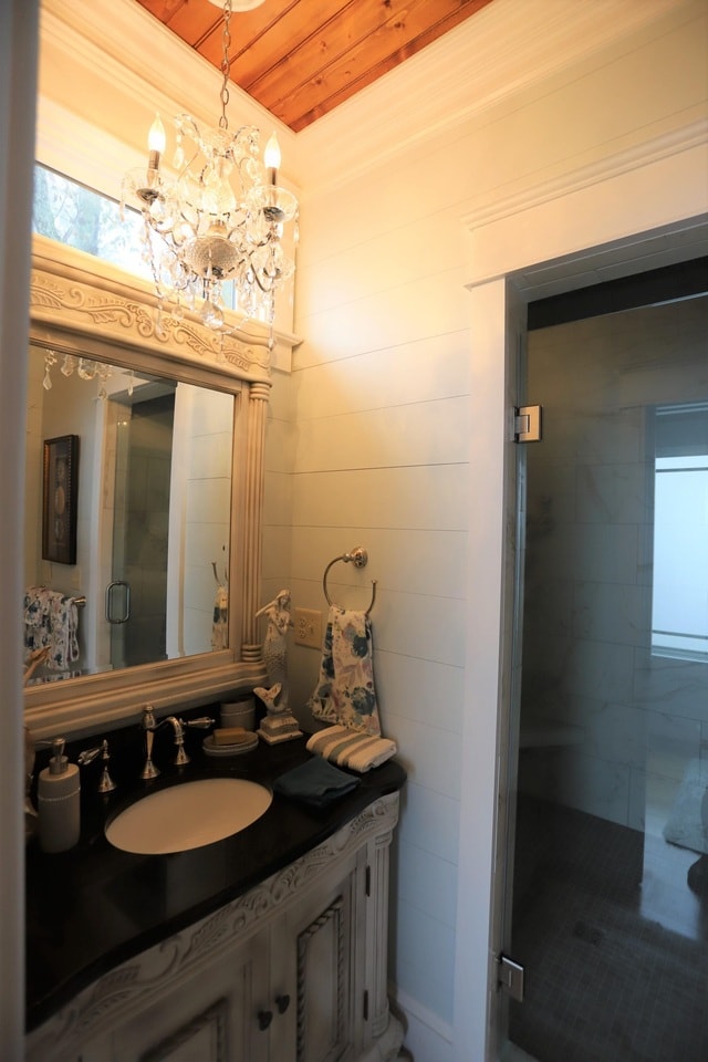 bathroom featuring walk in shower, wood ceiling, vanity, and a chandelier