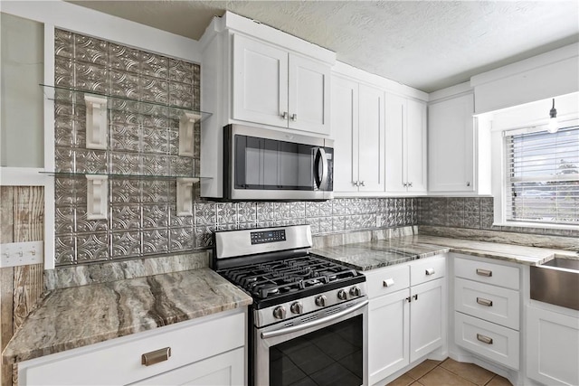 kitchen featuring decorative backsplash, white cabinetry, and stainless steel appliances