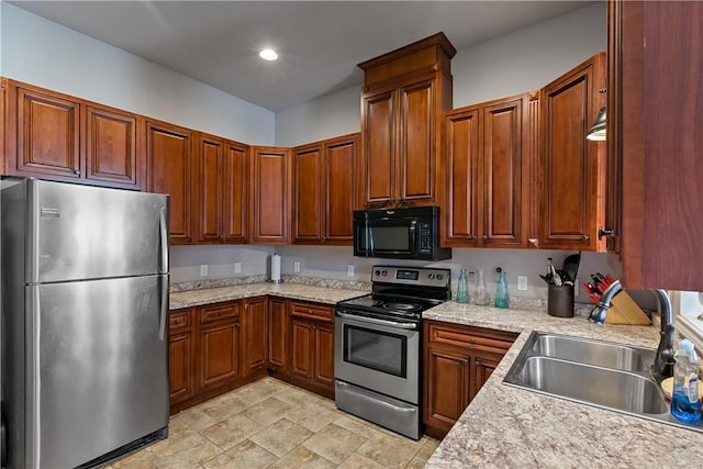 1205 Carolina St, College Station, TX 77840 - kitchen featuring light stone counters, recessed lighting, appliances with stainless steel finishes, brown cabinetry, and a sink