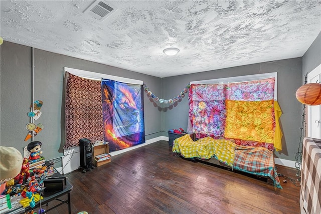 bedroom featuring a textured ceiling and dark hardwood / wood-style floors