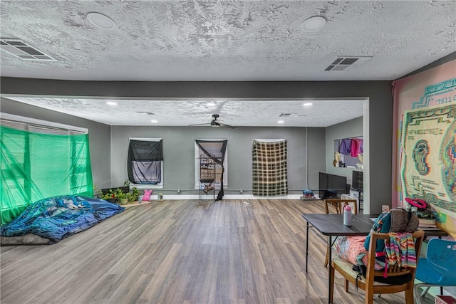 interior space with ceiling fan, hardwood / wood-style floors, and a textured ceiling