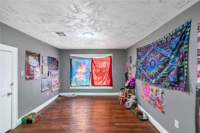 interior space with a textured ceiling and hardwood / wood-style flooring