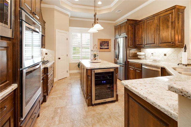 kitchen with decorative backsplash, light stone counters, stainless steel appliances, pendant lighting, and wine cooler